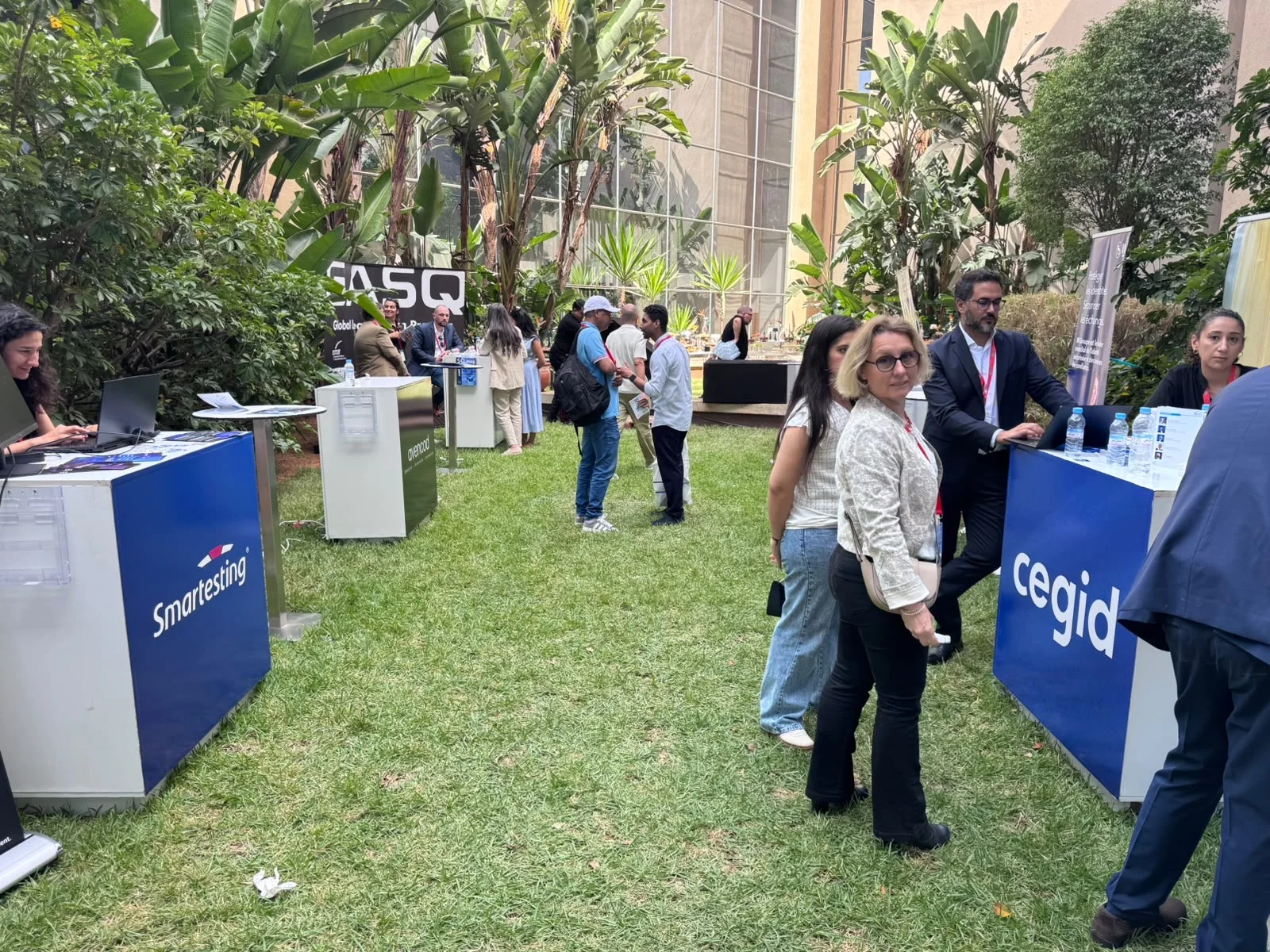 Vue des stands Smartesting, GASQ et Cegid avec plusieurs participants dans le jardin du Technopark.
