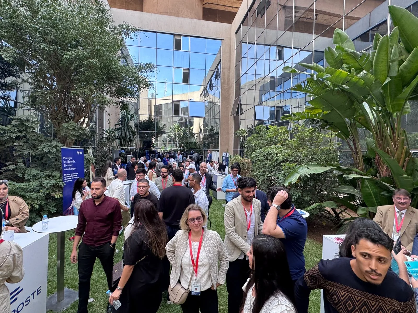 Des participants échangent entre les stands installés dans le jardin du Technopark.