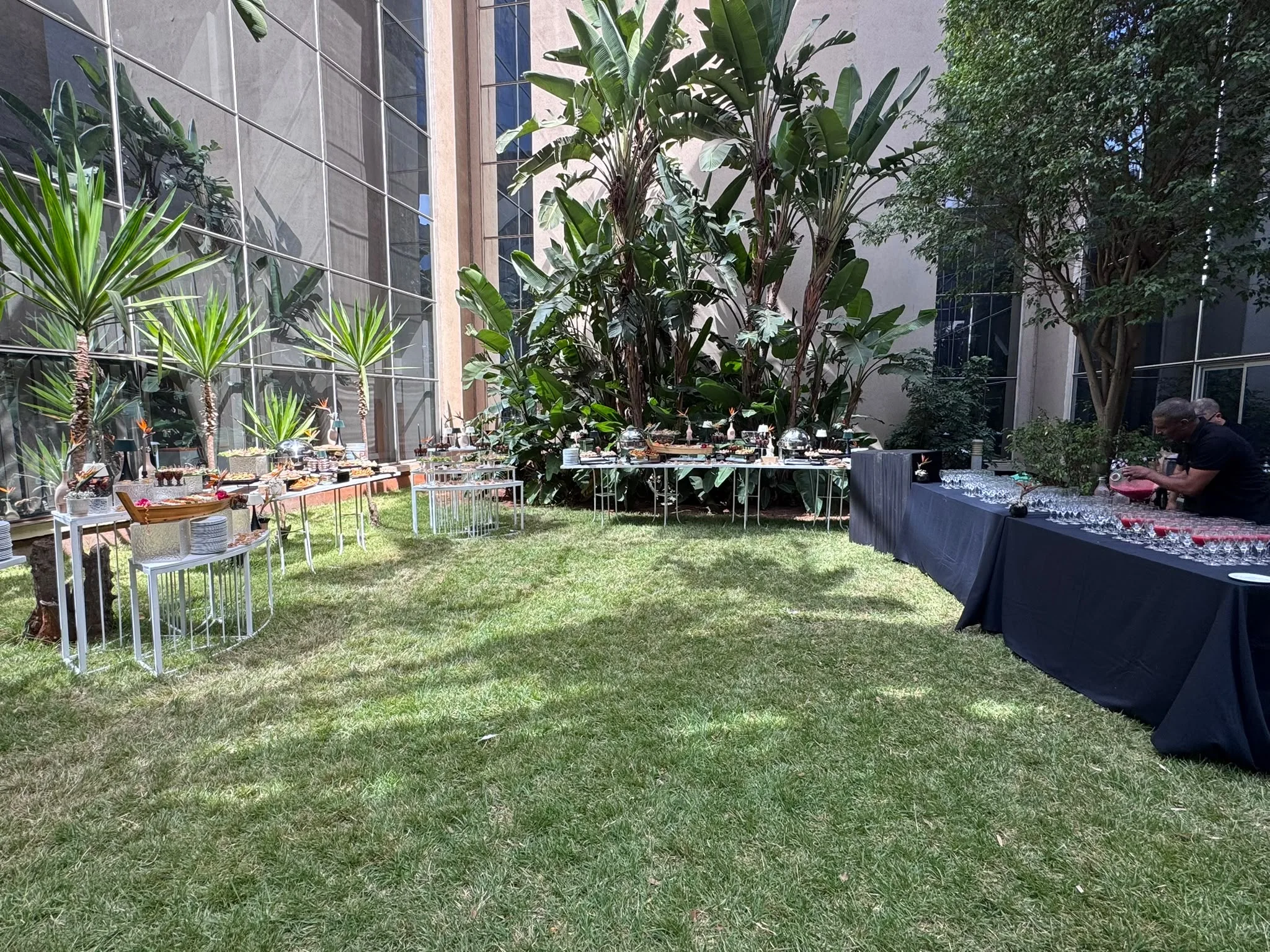 Le jardin du Technopark avec des plantes, des tables et l’espace de réception de la JMTL.