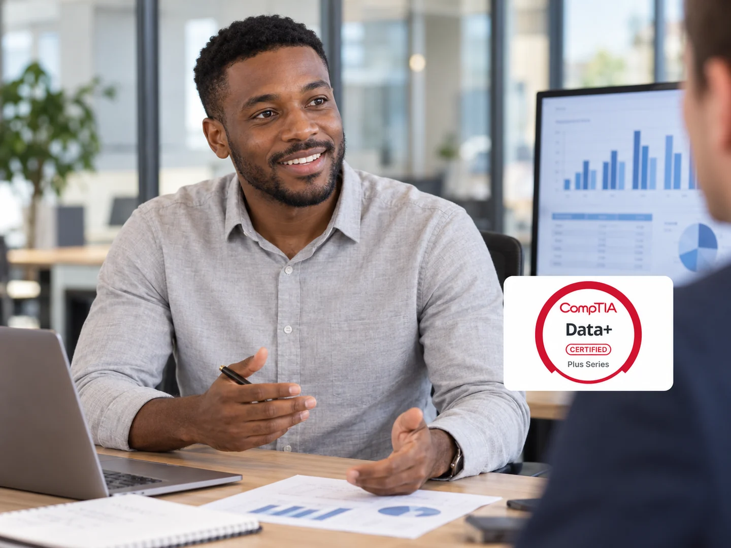 Analyste présentant des données, avec le logo CompTIA Data+ dans une pastille blanche.