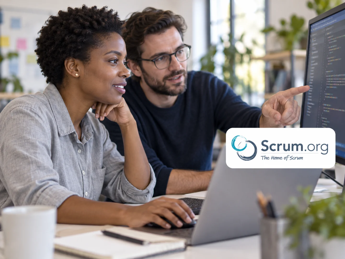 Développeurs collaborant sur du code, avec le logo Scrum.org.